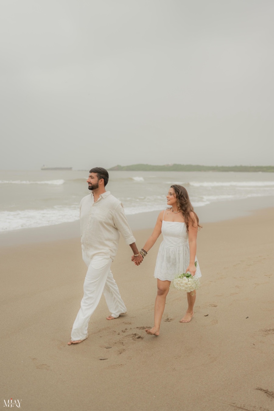 Viren and Pooja walking hand in hand on the beach